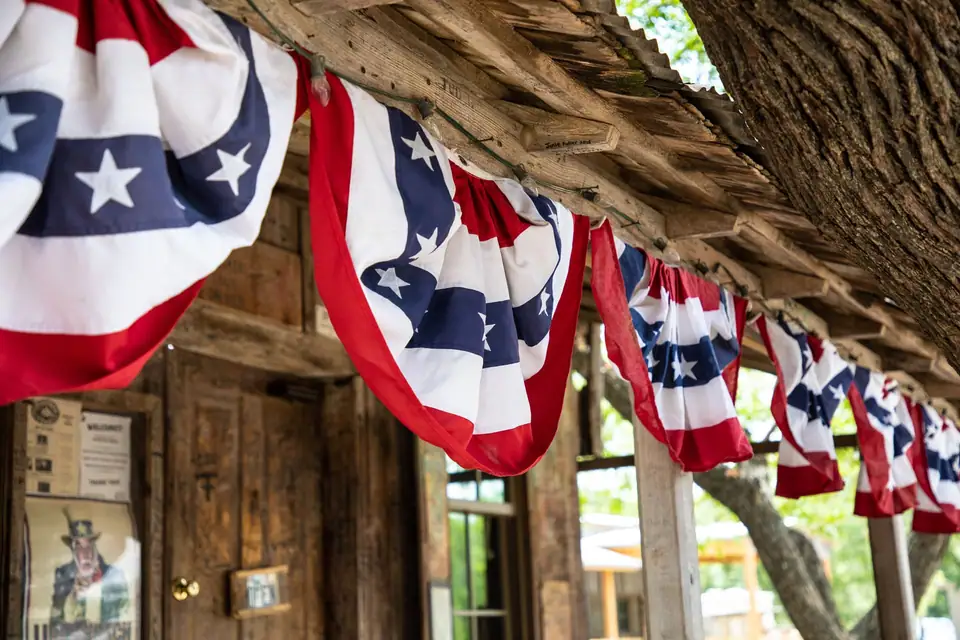 Red, white and blue star bunting hanging along the eave of a rustic wooden porch
