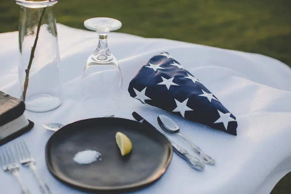 A white table setting with a folded navy star-print napkin beside a plate and cutlery